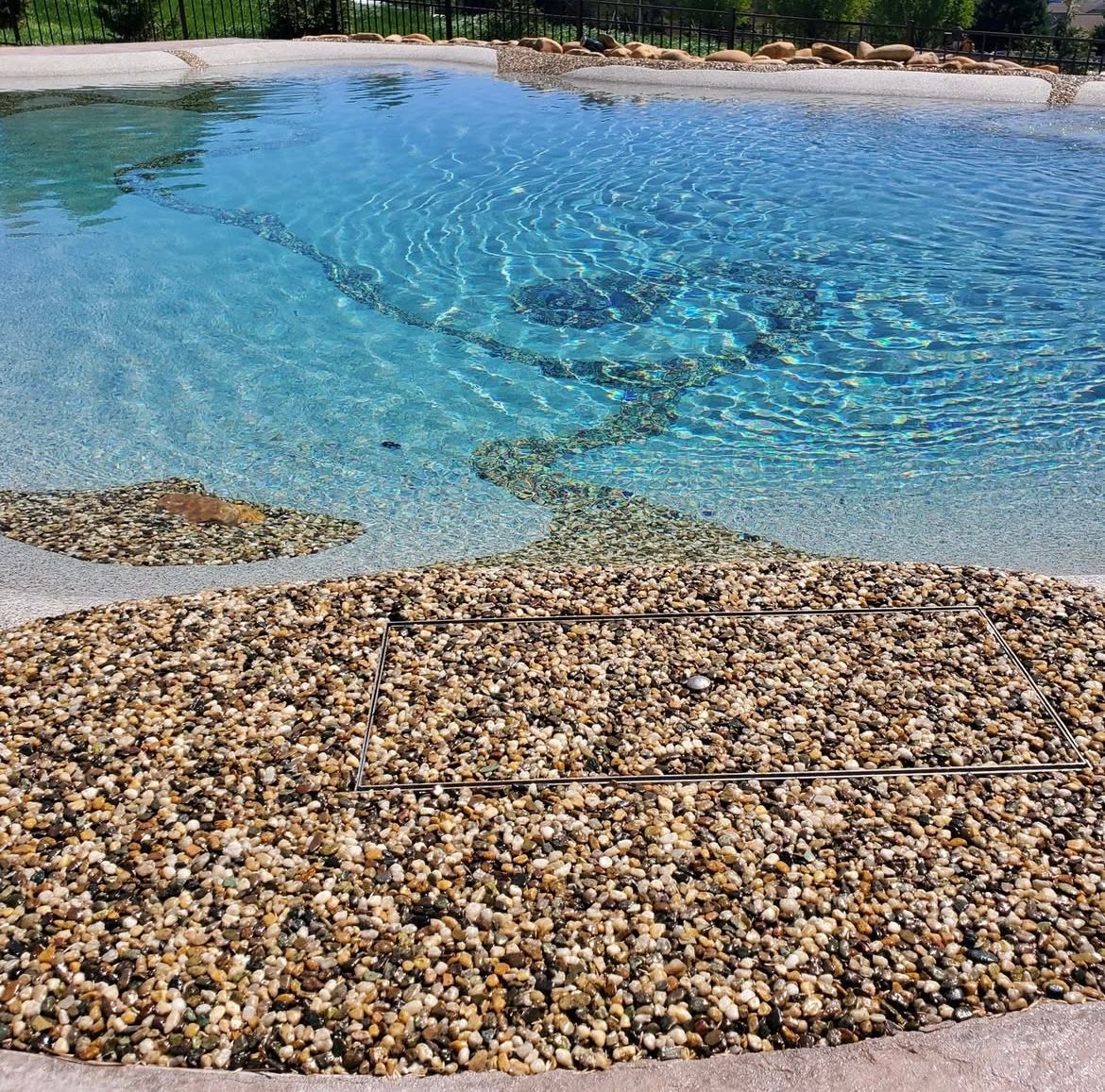 A large body of water surrounded by rocks and gravel.