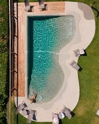 An aerial view of a swimming pool surrounded by chairs and a wooden deck.