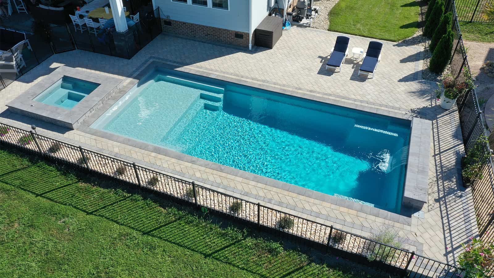 An aerial view of a large swimming pool in a backyard.