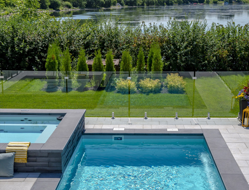 A large swimming pool with a view of a lake.
