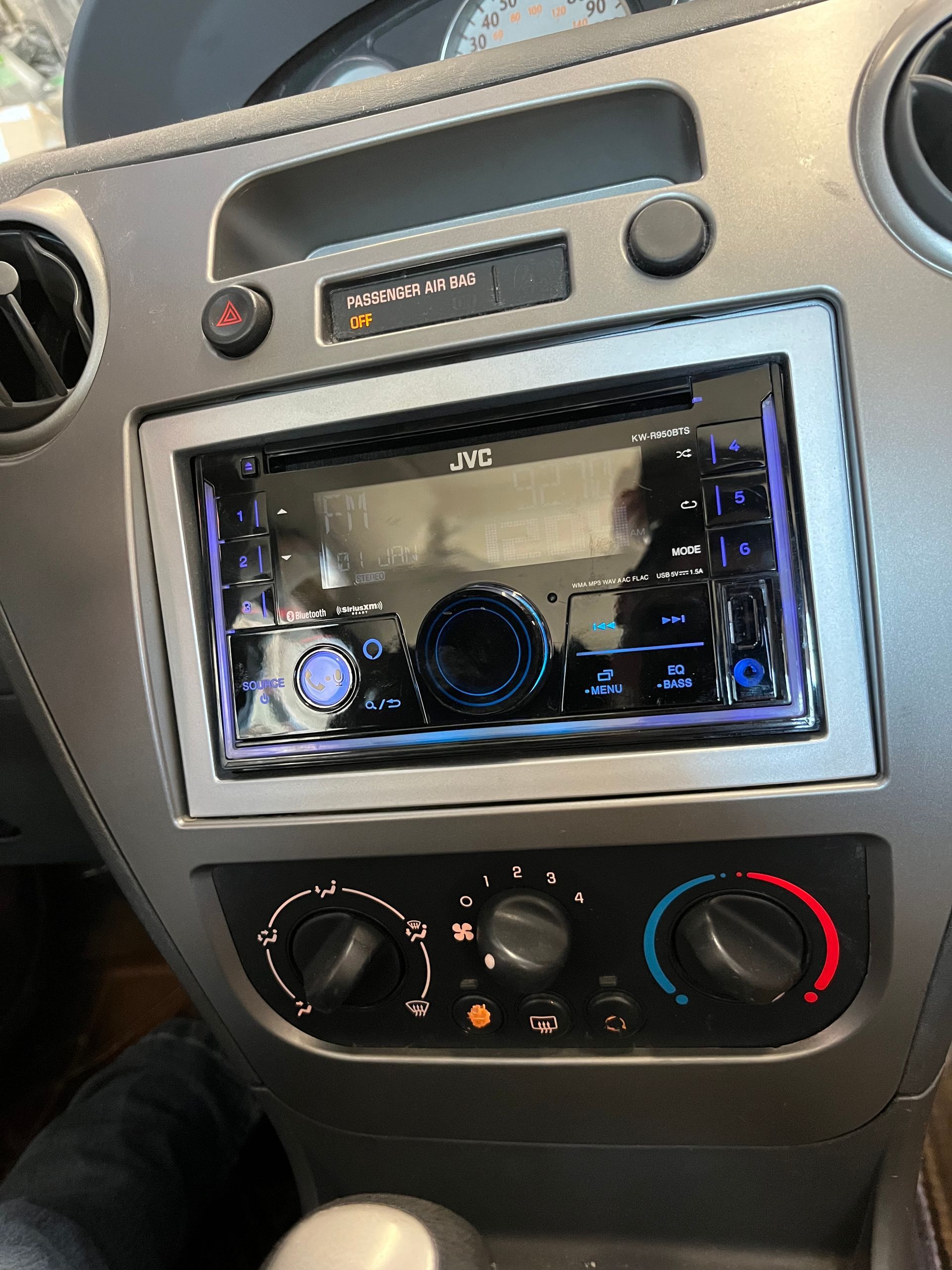 Car dashboard center console with touchscreen stereo and climate controls, silver trim, and black panel