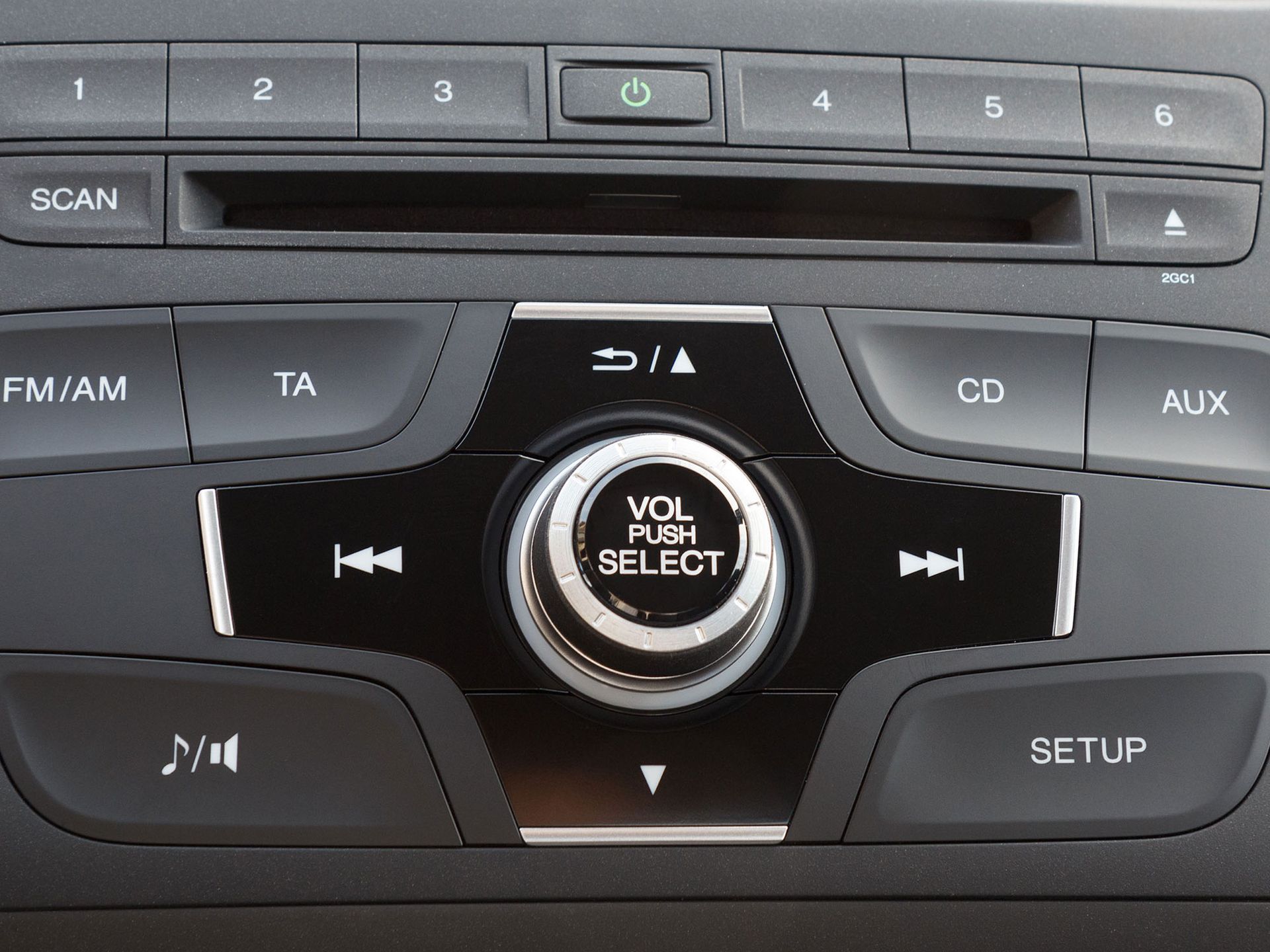 Car stereo control panel with buttons, volume knob, and CD/AUX, FM/AM, and setup labels