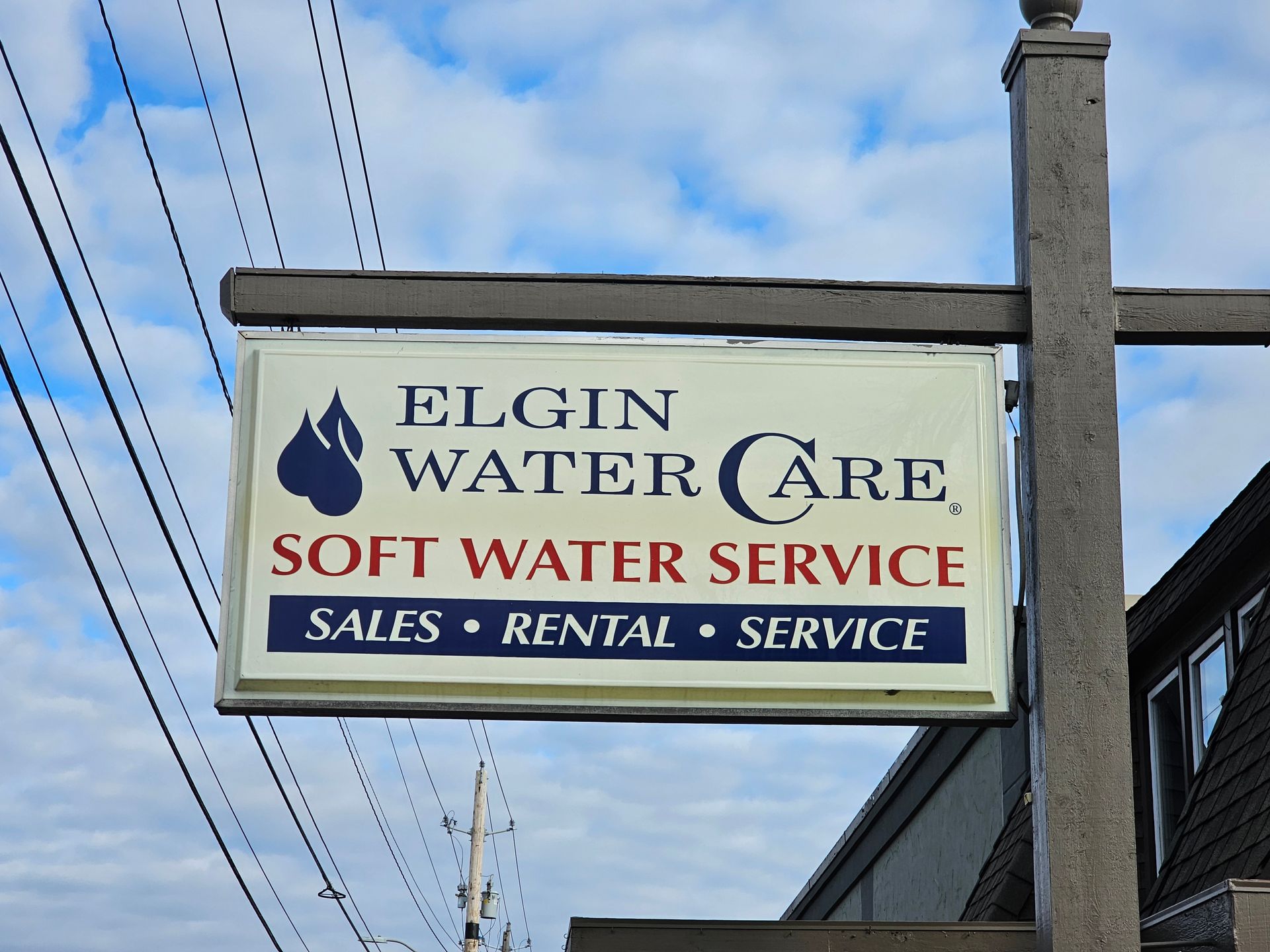 Sign for Elgin Water Care, featuring logo of water droplet; states 