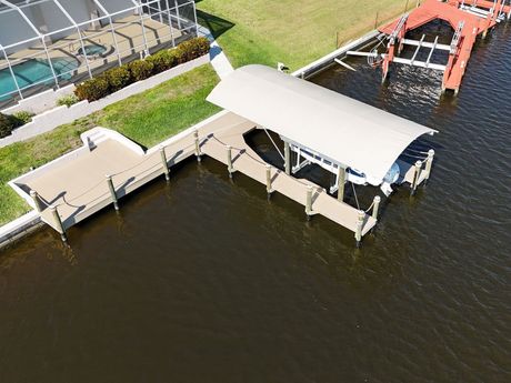 A pontoon boat is docked at a dock in the water.