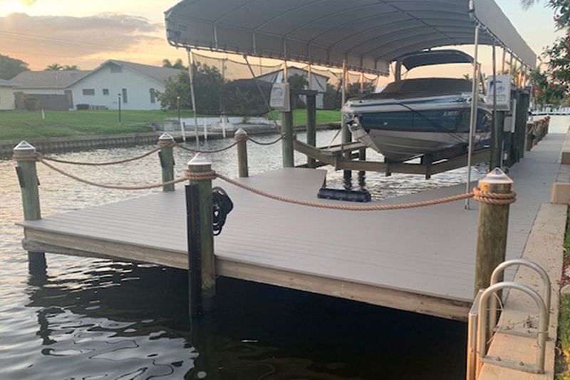 A boat is docked at a dock with a canopy over it.
