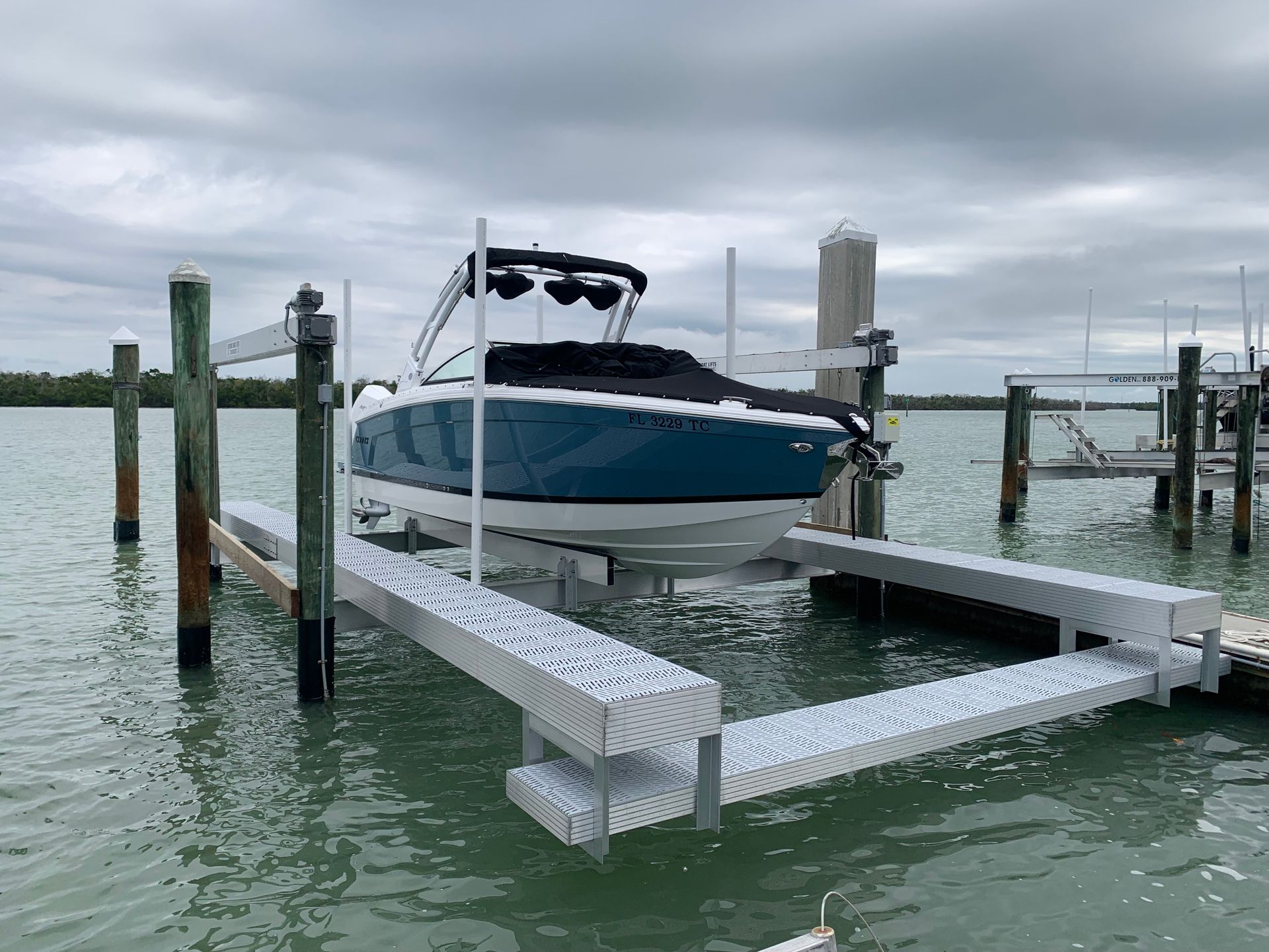 A blue and white boat is docked at a dock in the water.