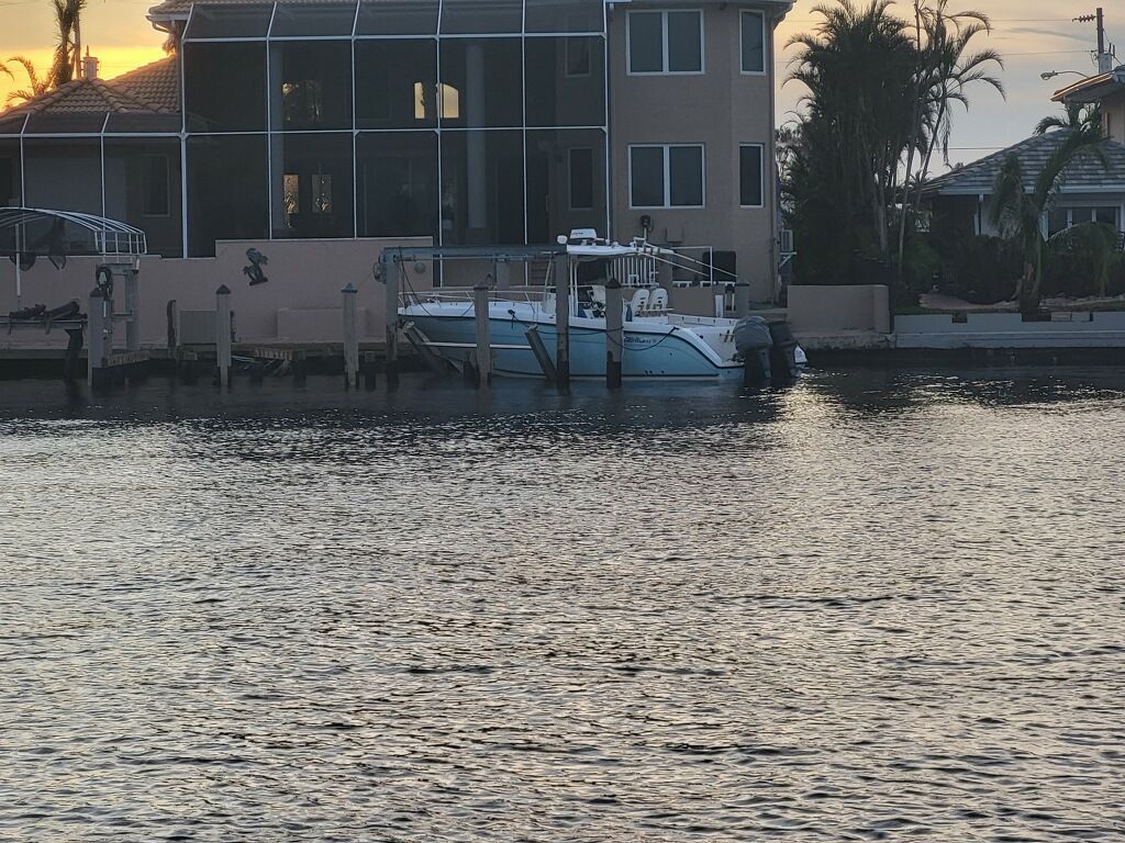 A boat is docked in front of a house in the water