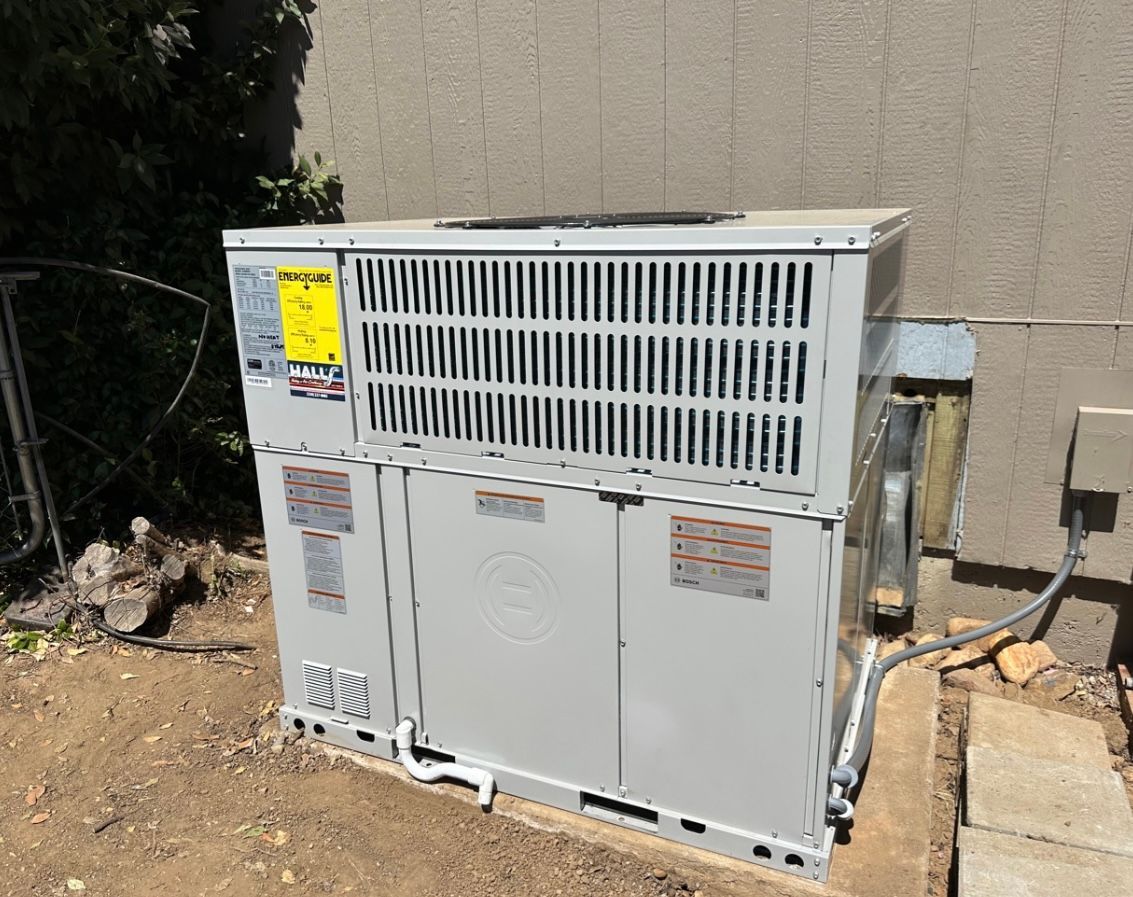 A large air conditioner is sitting outside of a building