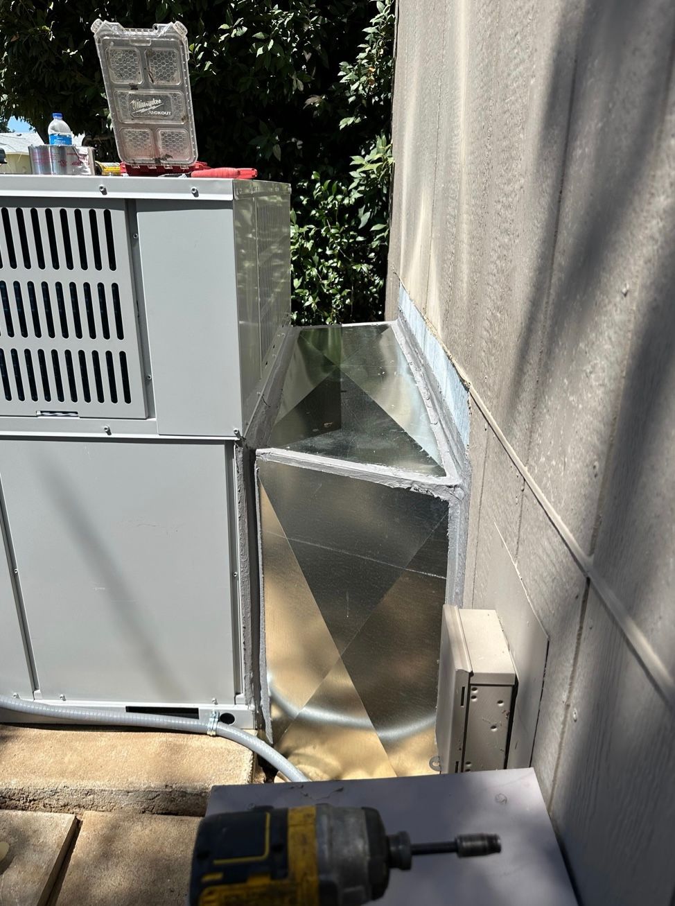 A drill is sitting on a table next to a refrigerator