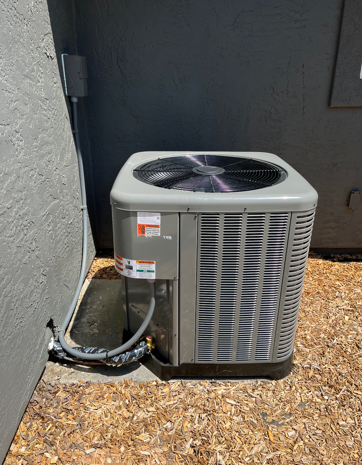 A large air conditioner is sitting on the side of a building
