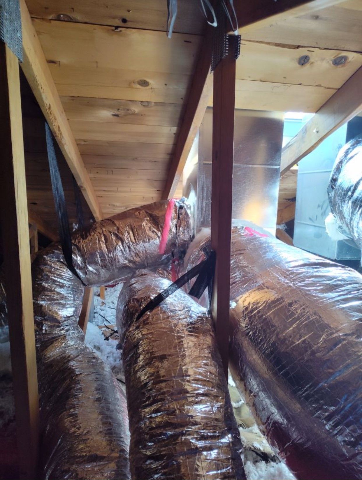 A bunch of ducts are hanging from the ceiling of a room