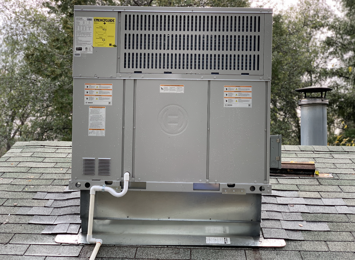 A large air conditioner is sitting on top of a roof