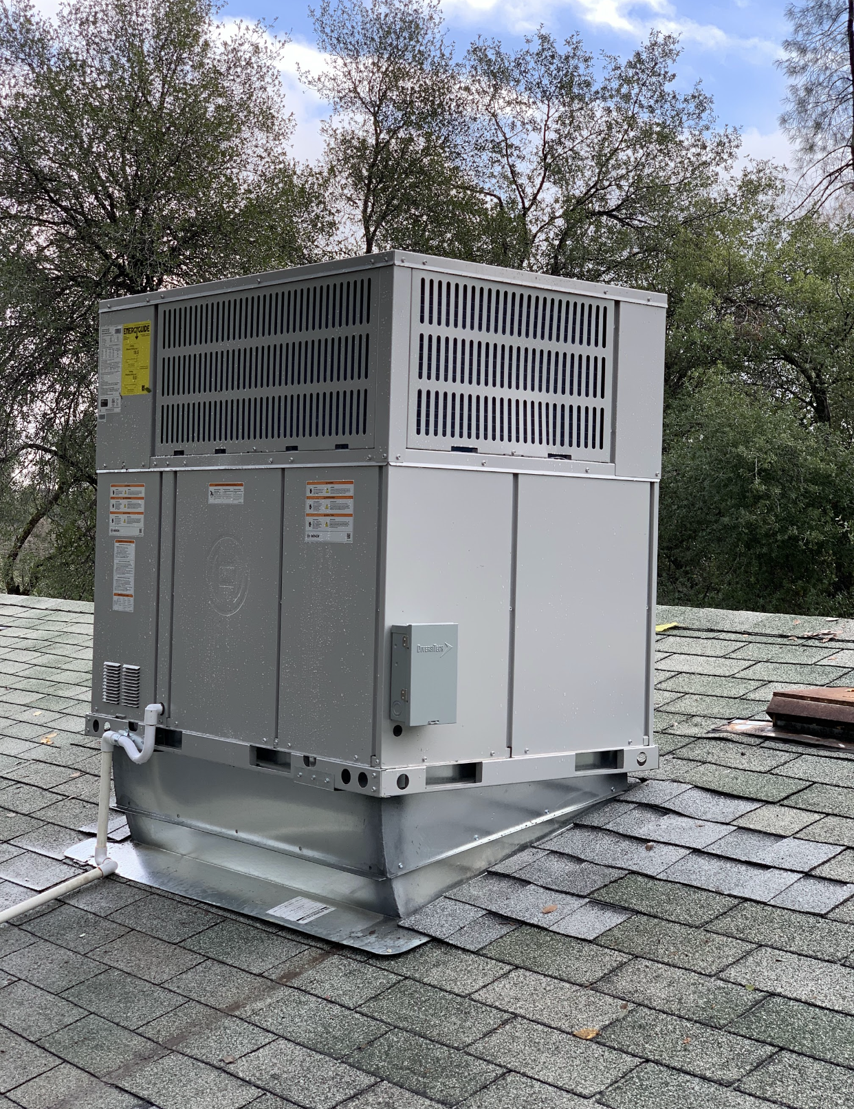 A large air conditioner is sitting on top of a roof