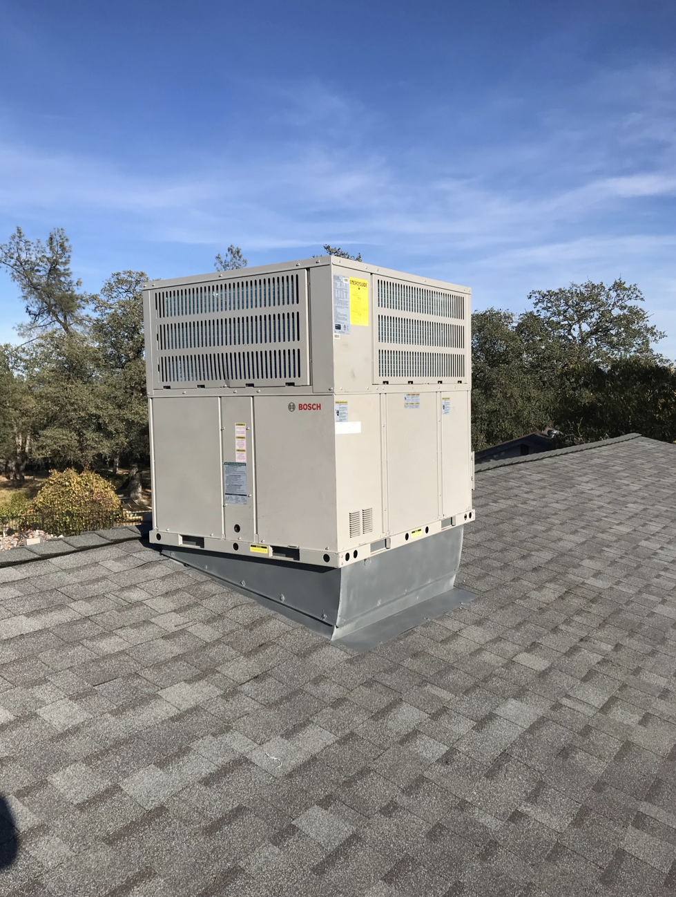 A large air conditioner is sitting on top of a roof
