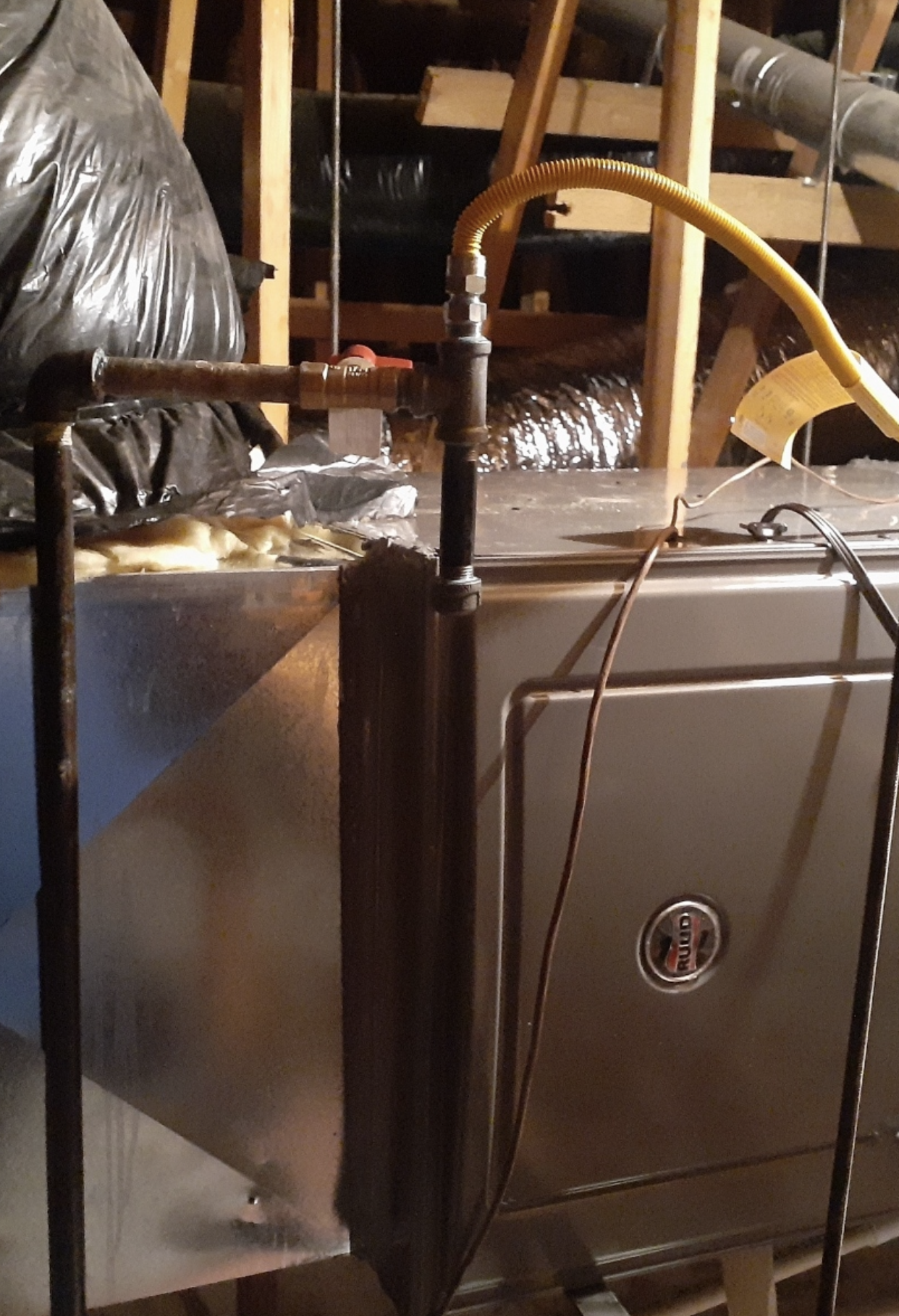 A hose is attached to a metal pipe in a room