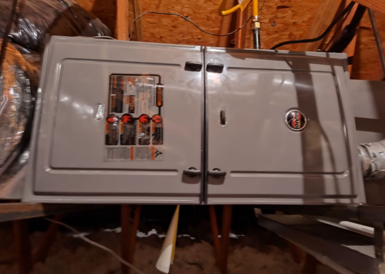 A gray electrical box is sitting in the attic