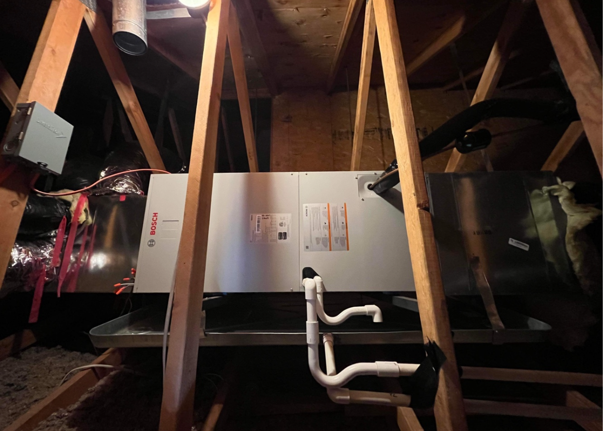 A white box is sitting in the attic of a house