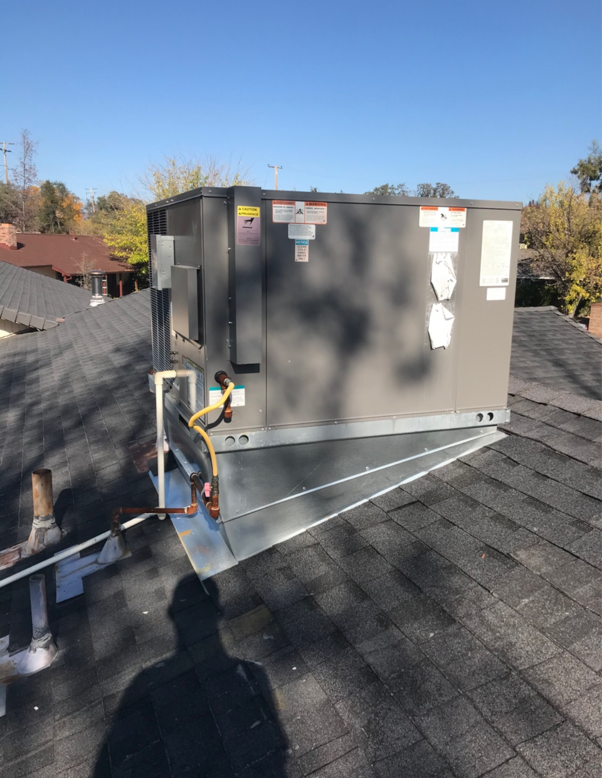 A large air conditioner is sitting on top of a roof