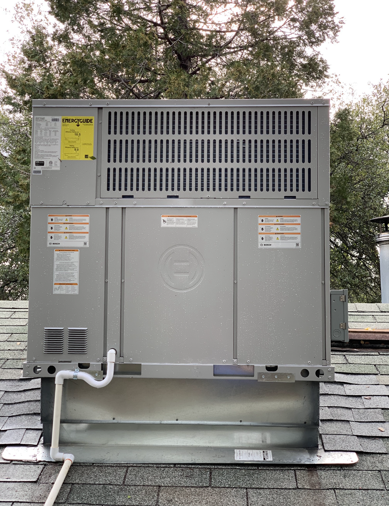 A large air conditioner is sitting on top of a roof