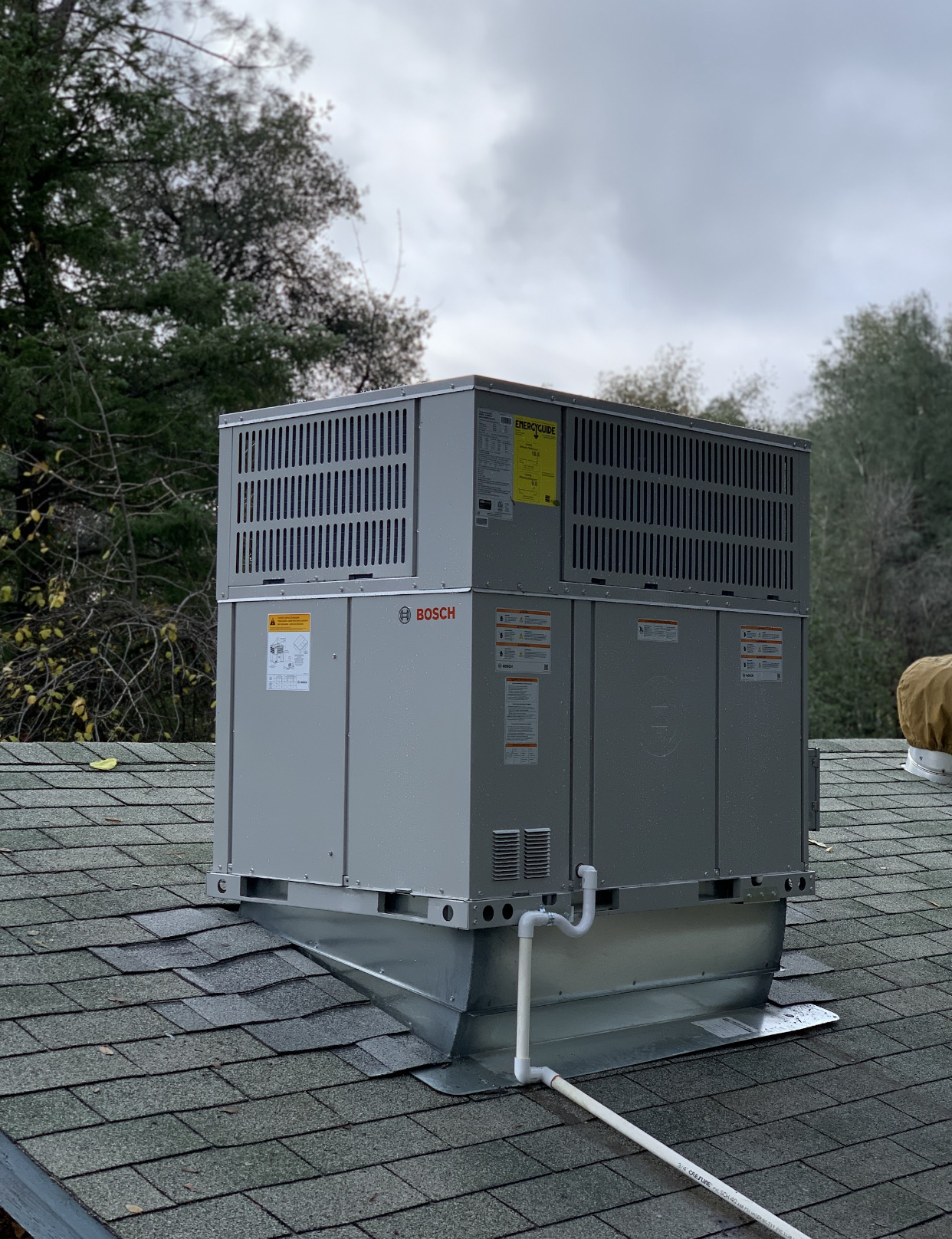 A large air conditioner is sitting on top of a roof