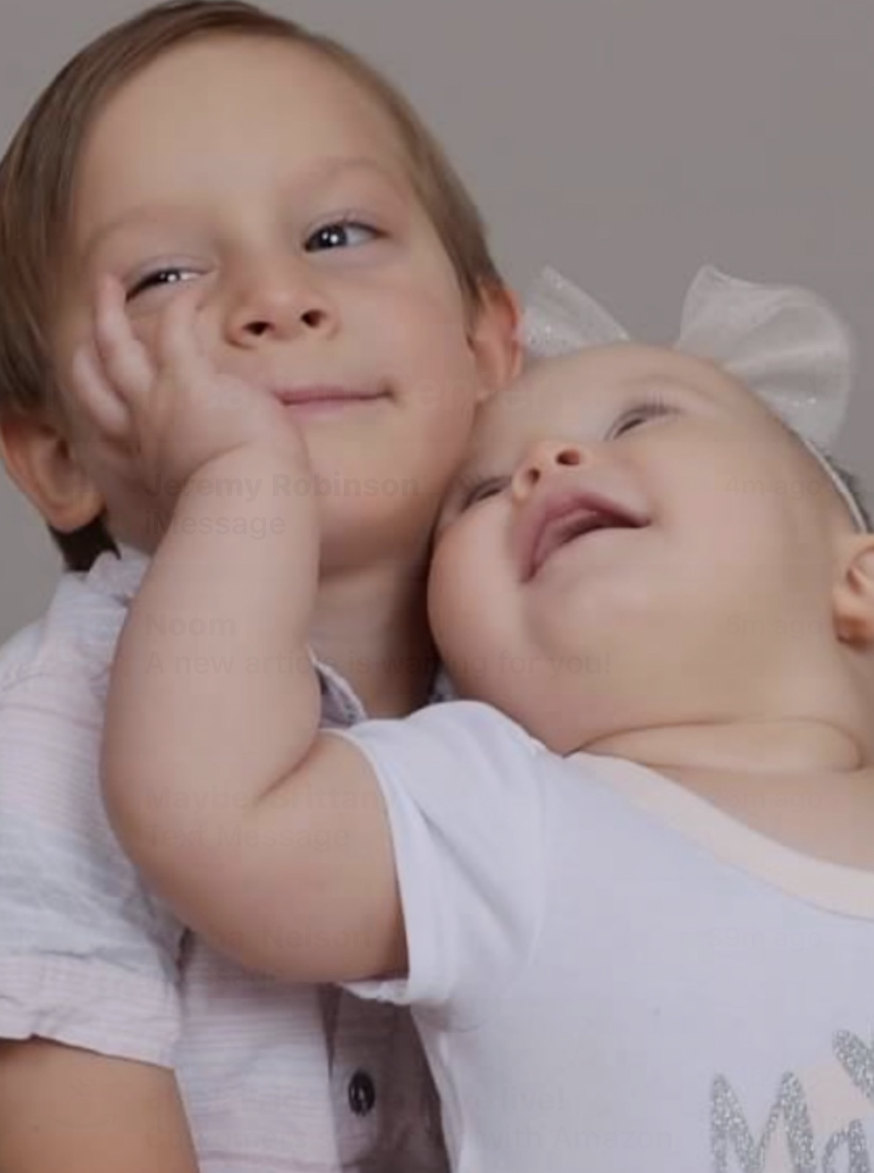 A little boy is holding a baby in his arms