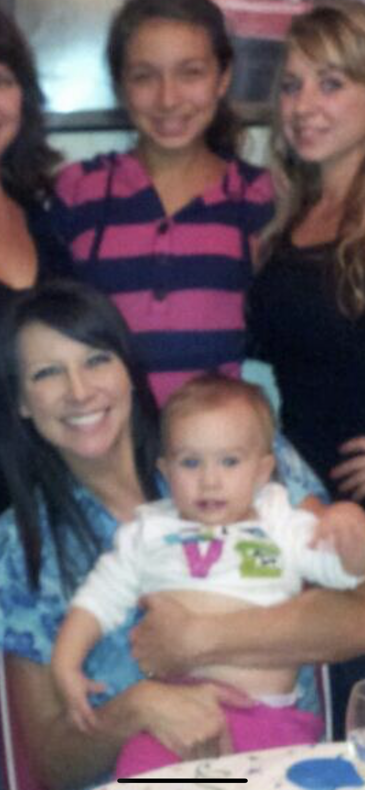 A woman holding a baby with the letter v on it