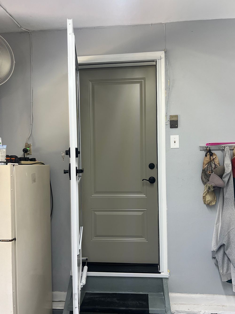 Grey door slightly ajar, set in gray-painted walls and a white door frame.