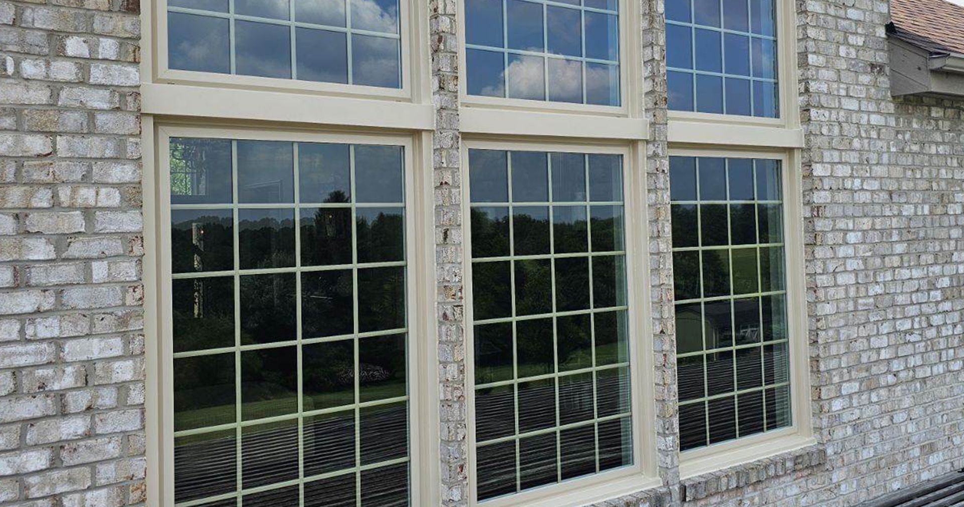 Brick exterior with large windows; beige frames and divided panes.