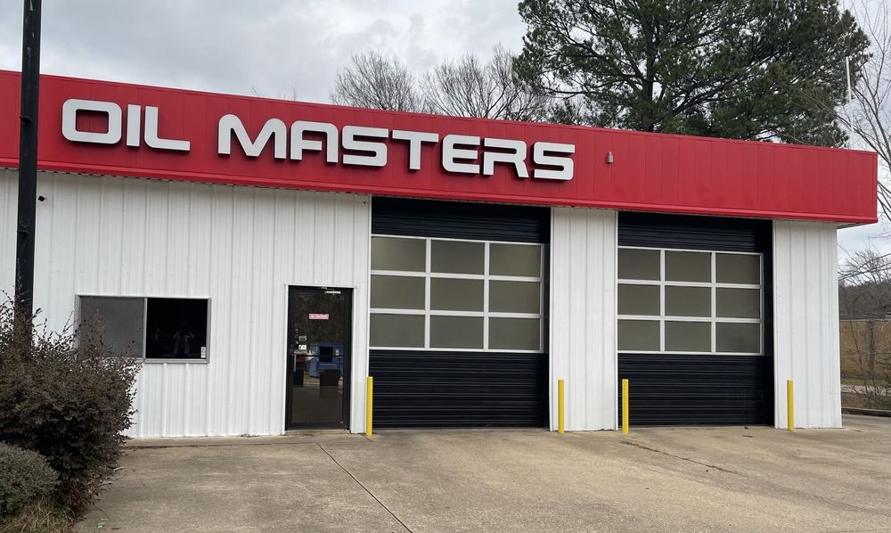 Oil Masters auto shop exterior with red and white facade, black garage doors.