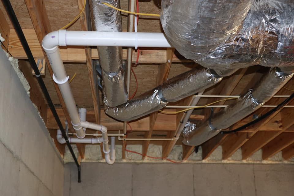 A bunch of pipes are hanging from the ceiling of a building.