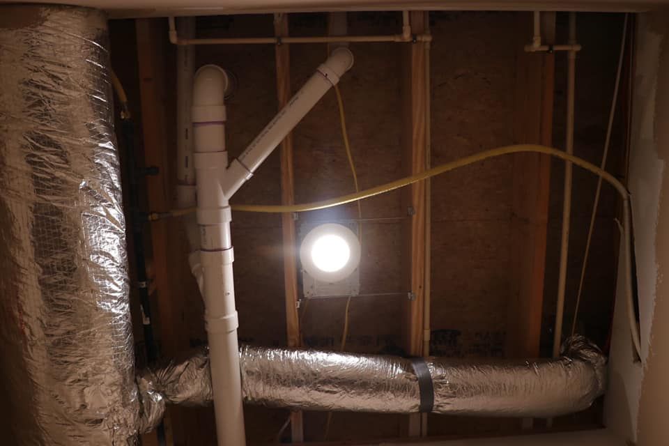 A room with a lot of pipes and a light on the ceiling