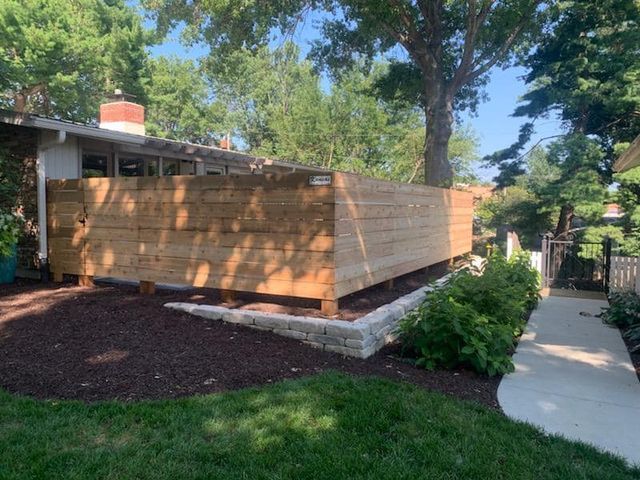 A wooden fence is sitting in front of a house.