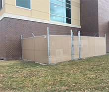 A fence is sitting in front of a large building.