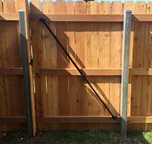 A wooden fence with a metal railing attached to it.