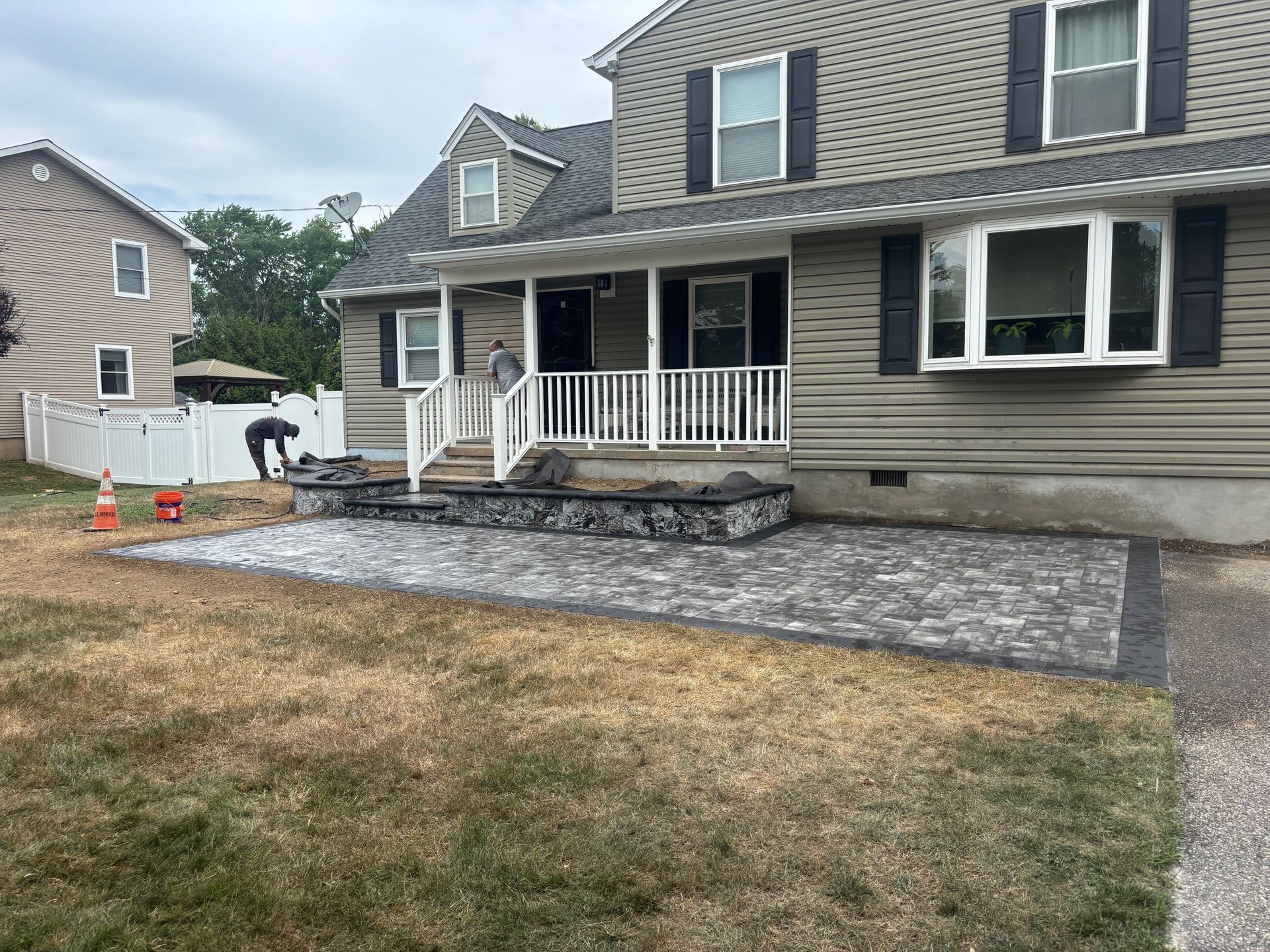 House exterior with stone front porch and a gravel walkway being installed in the yard
