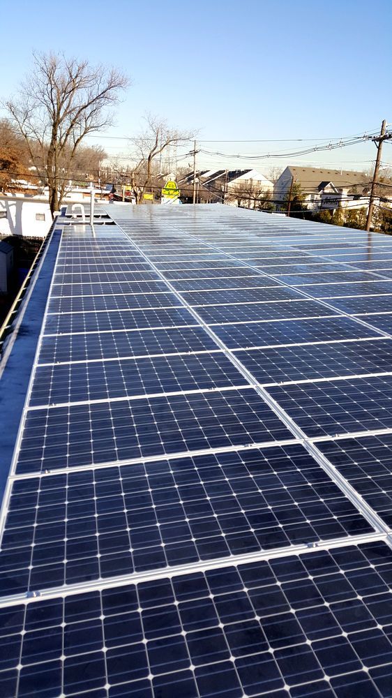 A row of solar panels on the roof of a building.