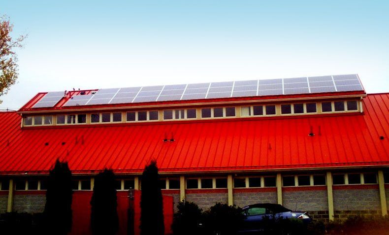 A building with a red roof and solar panels on it.