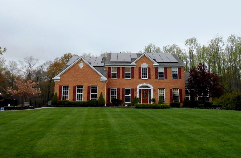 A large brick house with solar panels on the roof.