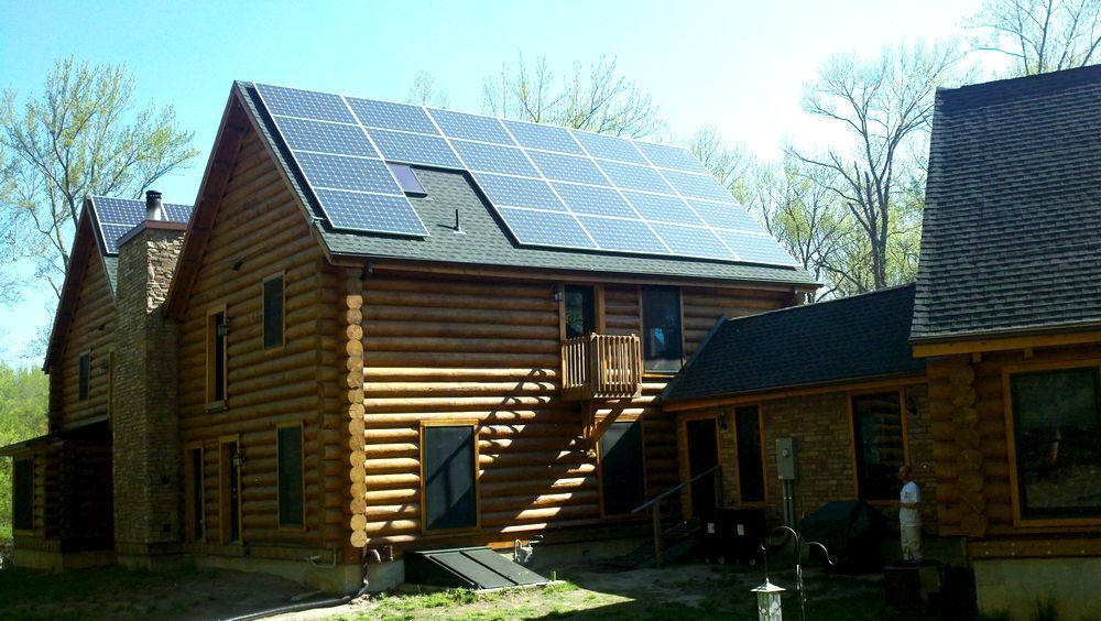 A log cabin with solar panels on the roof.