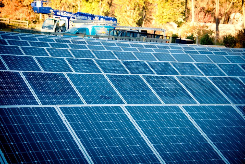 A row of solar panels are sitting on top of a roof.