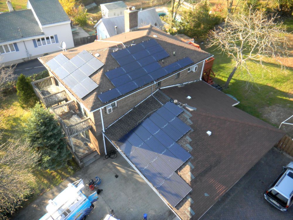 An aerial view of a house with solar panels on the roof.