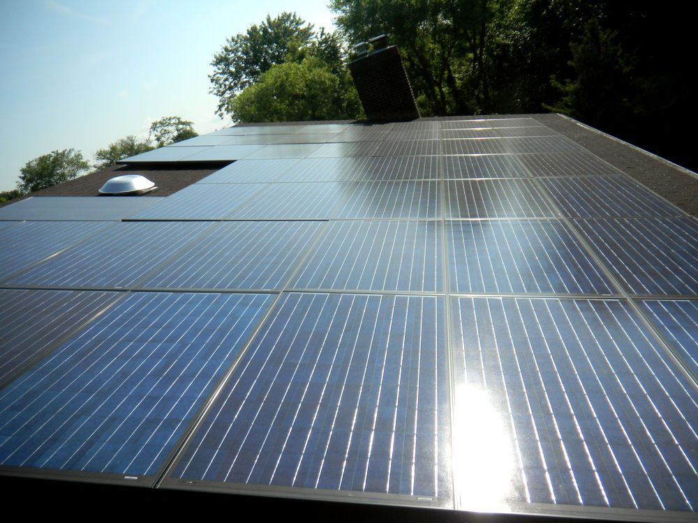 A row of solar panels on the roof of a house.