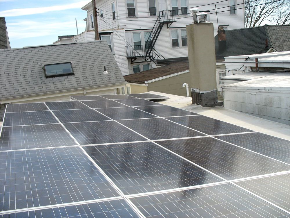 A row of solar panels on the roof of a building.
