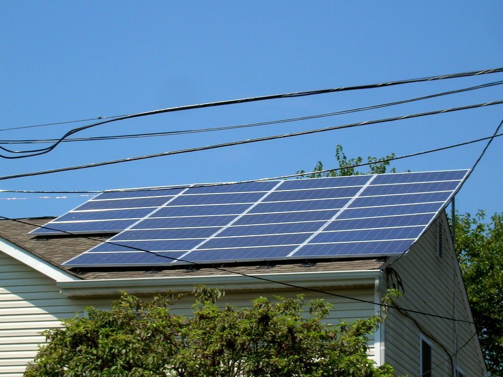 A row of solar panels on the roof of a house.