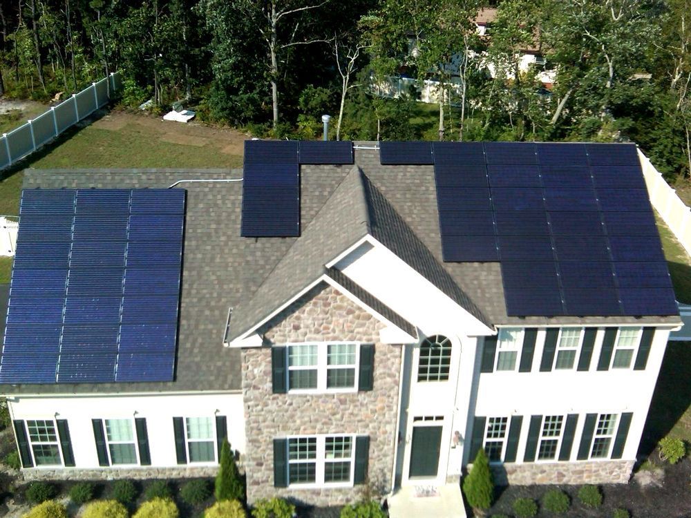 An aerial view of a house with solar panels on the roof.