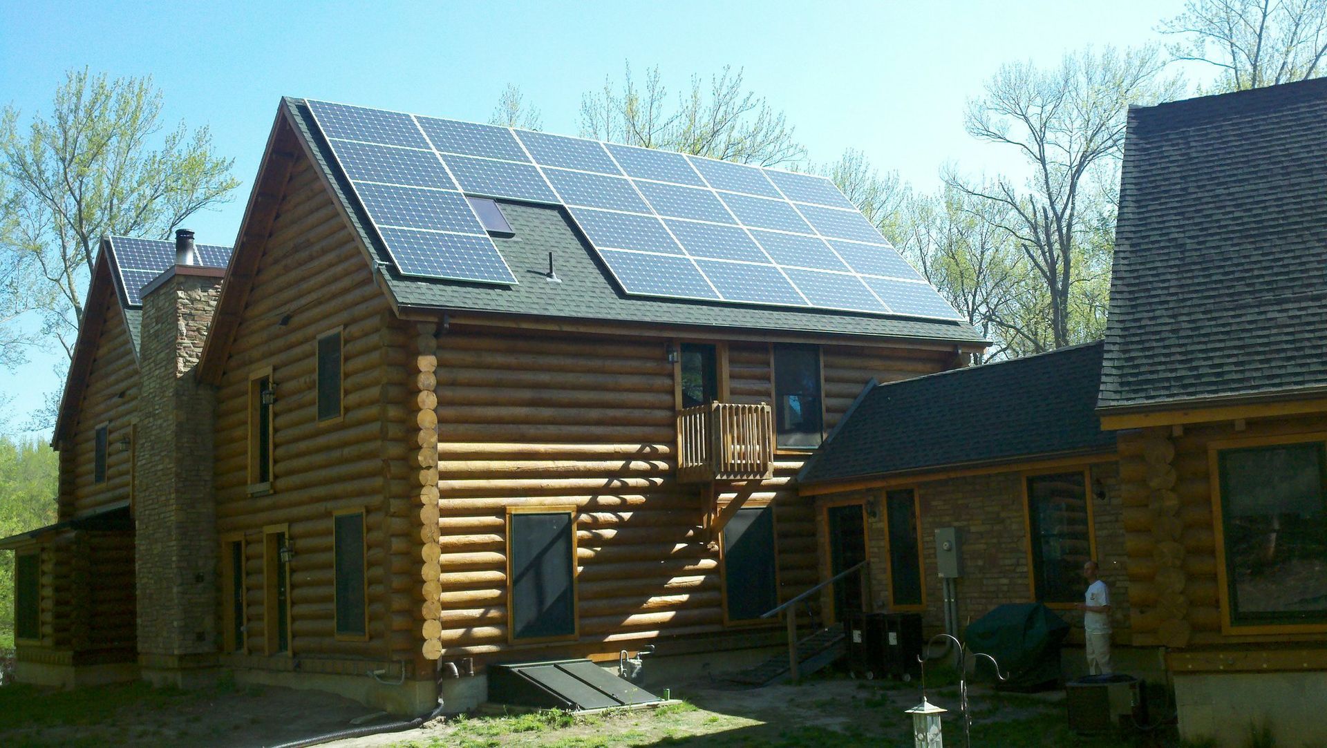 A log cabin with solar panels on the roof.