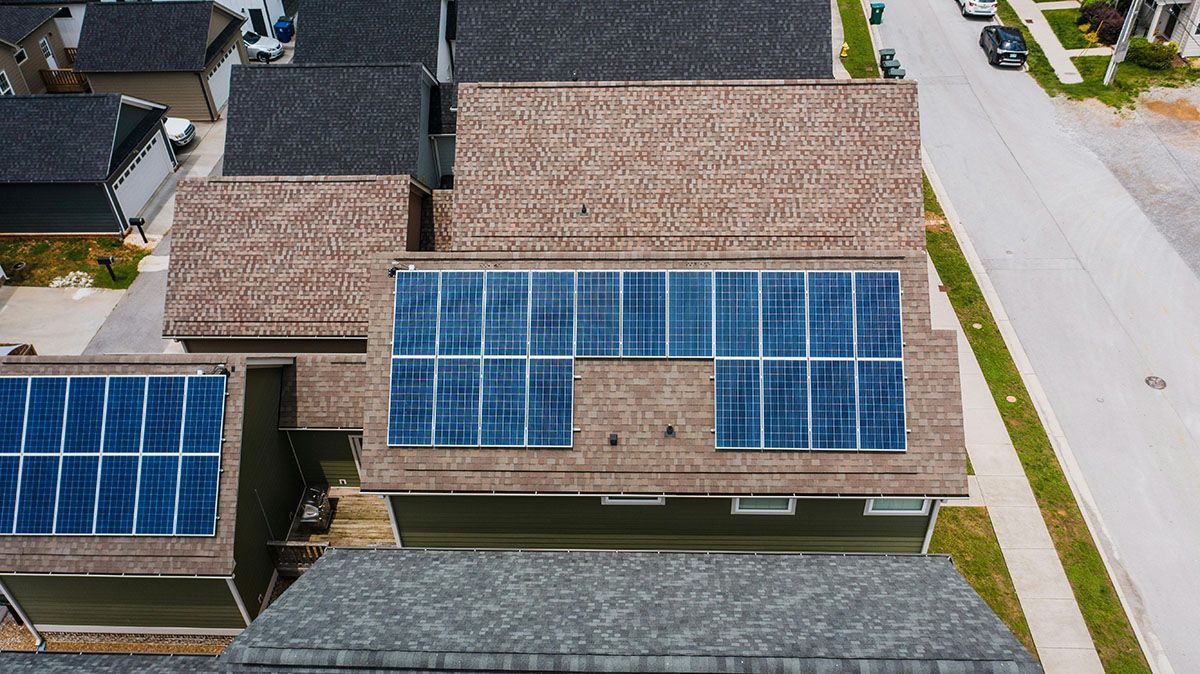 An aerial view of a house with solar panels on the roof.
