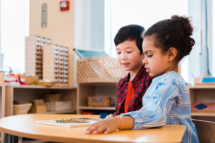 A boy and a girl are sitting at a table in a classroom.