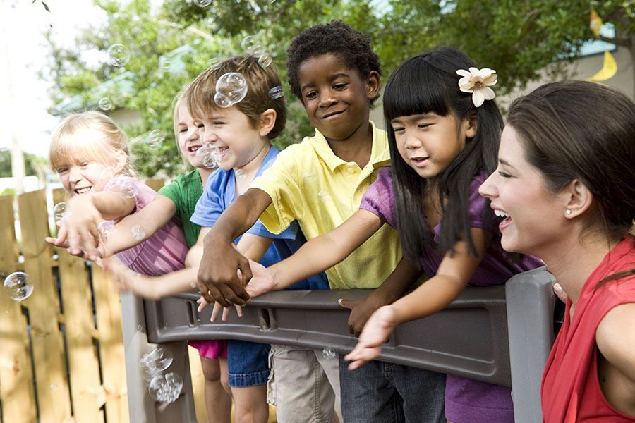 A woman is standing next to a group of children.