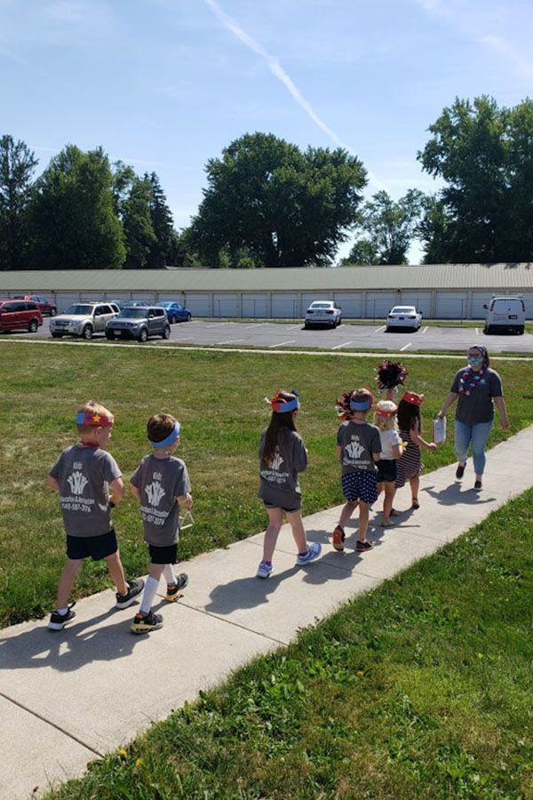 A group of children are walking down a sidewalk.